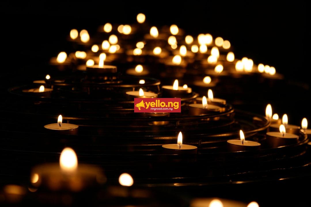 Dozens of lit candles glowing in the dark during a memorial tribute vigil